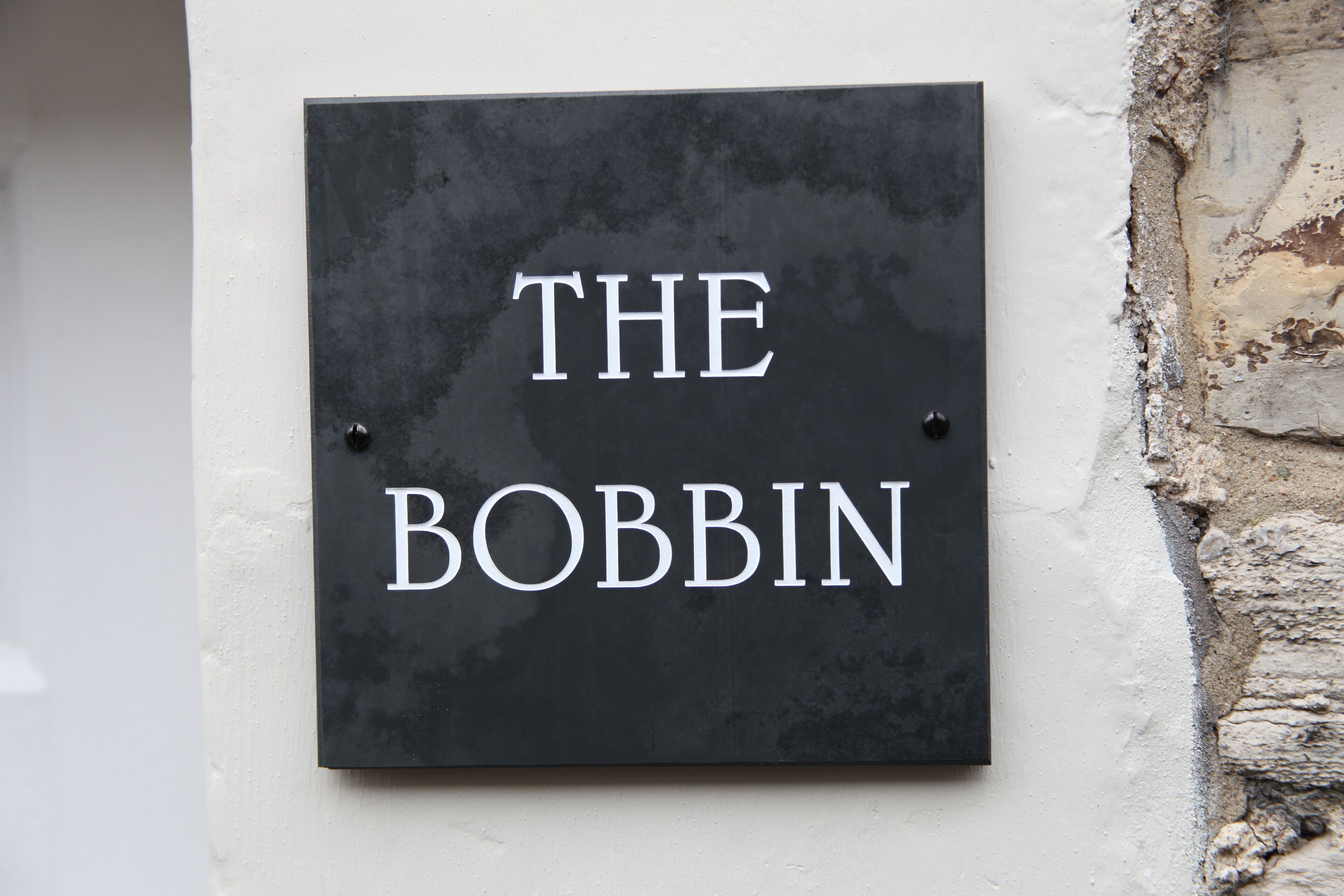 A black sign with white lettering that reads "THE BOBBIN".