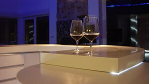 Et moderne interiør med et rundt bord og to glas rødvin.