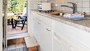 A kitchen with a sink, countertop, and cabinets.
