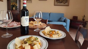 Een eettafel met twee borden pasta, een fles wijn en twee wijnglazen.