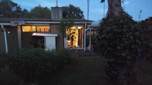 Asuinrakennus, jossa on selvästi näkyvissä oleva savupiippu, pääovi ja pieni kuistialue.