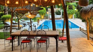 An outdoor patio with a table and chairs, a pool, and a pergola with hanging lights. - ARLES Camargue, Character Arles House with Pool (Arles)