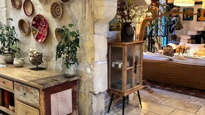 A rustic interior with stone walls, a wooden counter, and a display cabinet. - ARLES Camargue, Character Arles House with Pool (Arles)