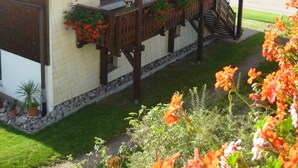 A two-story building with a sloped roof, solar panels, and a balcony with red flowers. - Vacation on a farm - discover and experience nature (Baden-Württemberg)