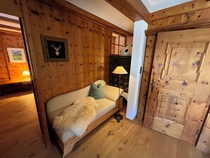 Ein Holzinnenraum mit einer Couch, einer Lampe und einer Tür.
