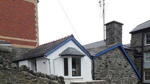 A stone building with a blue door and a window.