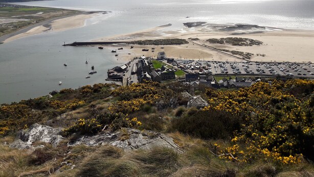 A coastal town with a marina, sandy beaches, and a parking area.