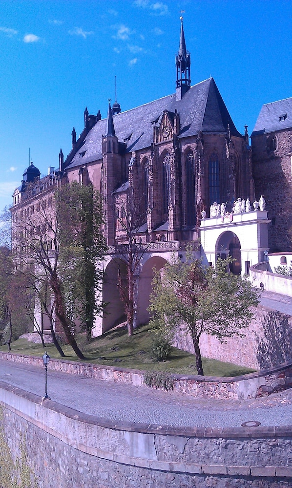 A historic building with a prominent tower and arched windows.