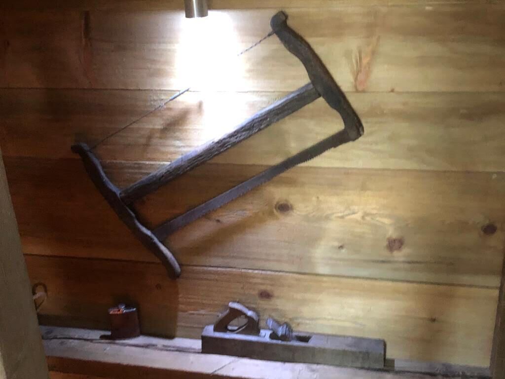 Un interior rústico de madera con una herramienta de metal colgada en la pared.
