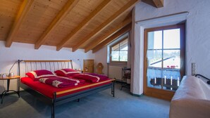 Un dormitorio con cama, ventana y techo de madera.