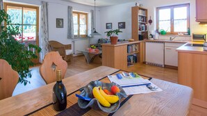 Una cocina moderna con comedor, muebles de madera y vistas al exterior.