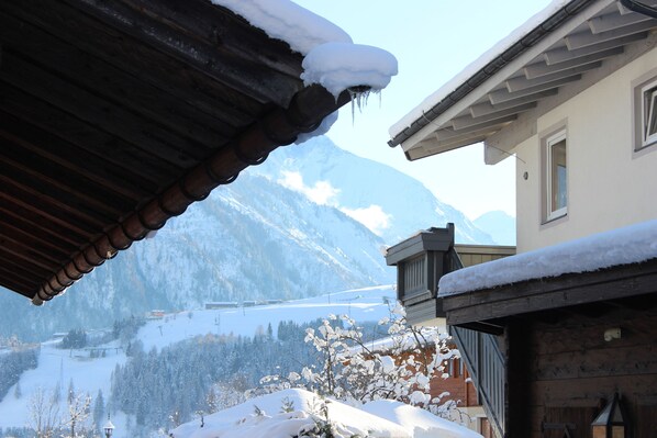 A mountain view with a wooden building and snow-covered roof. - Chalet Bergbach: ultimate holiday feeling in your own home! (Piesendorf)