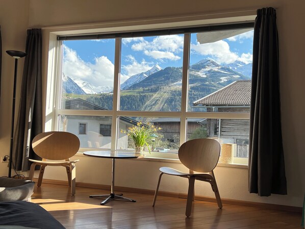 A room with a large window, two chairs, a small table, and a lamp. - Chalet Bergbach: ultimate holiday feeling in your own home! (Piesendorf)