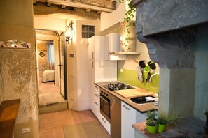 Eine Küche mit Herd, Backofen und einer Essecke inklusive Tisch und Stühlen.