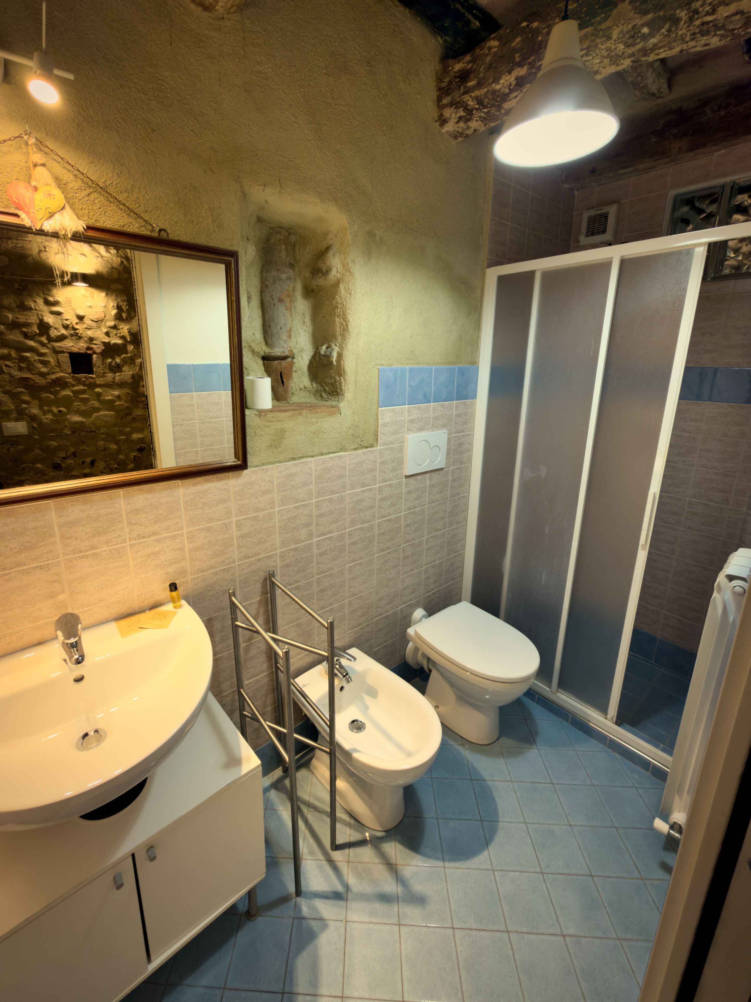 A bathroom with a sink, toilet, and shower area.