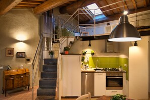 Une cuisine équipée d’une cuisinière à gaz, d’appareils électroménagers en acier inoxydable et d’un crédence de couleur verte.