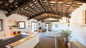 A spacious kitchen with a wooden island, white cabinetry, and a rustic ceiling. - House with pool, 20.000 m2 garden, ping-pong close to the beach for 18 people (Sant Andreu de Llavaneres)