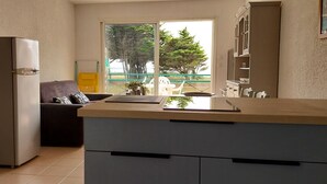 Una cucina funzionale con frigorifero, un tavolo da pranzo e vista sull'esterno.