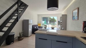 Una cucina moderna con isola centrale, piano cottura integrato e una scala nera.