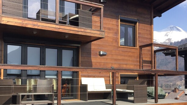 Ein zweistöckiges Holzhaus mit Balkon, Außenbereich und Whirlpool.