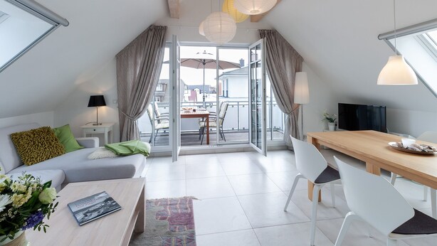 Um apartamento moderno com varanda, área de jantar e sala de estar.