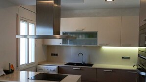Eine moderne Küche mit Kochinsel, Backofen und Edelstahlgeräten.