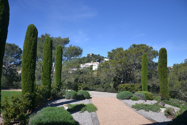 A garden with a gravel path, neatly trimmed hedges, and tall trees. - Modern cosy villa near beaches and village of Begur. Calm and green surrounding (Begur)