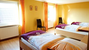 A room with two beds, a chair, and a radiator. - spacious apartment in the countryside, ideal starting point for cycling (Rosendahl)