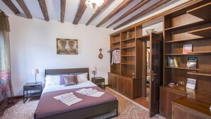A bedroom with a large bed, wooden wardrobe, and a painting on the wall. - Venetian Historic Residence at Rialto Market Square (Venezia)