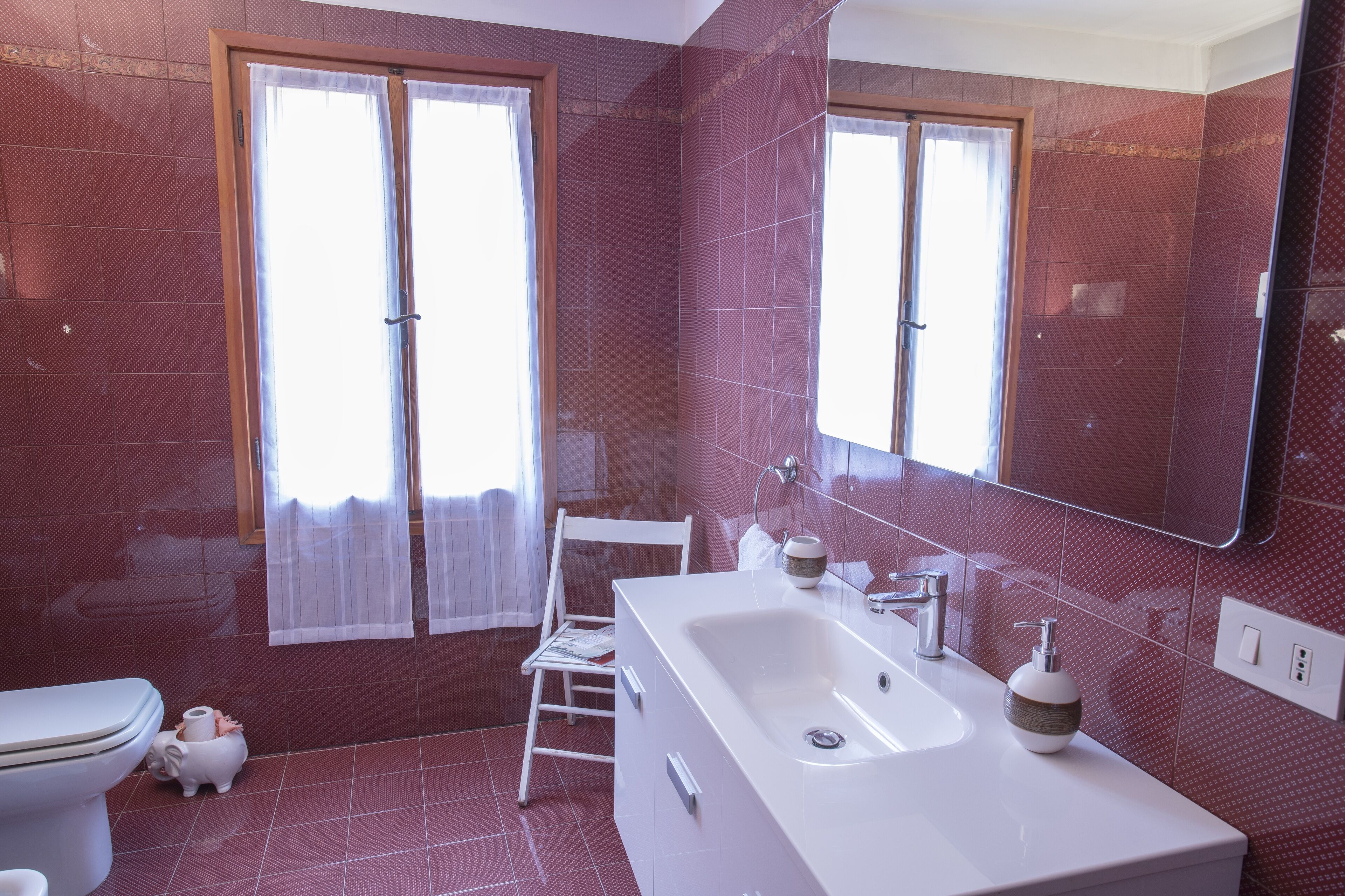 A bathroom with a large white bathtub, a white toilet, and a white sink.