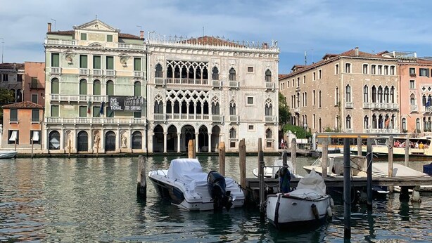 A historic building with arched windows and a central courtyard, surrounded by water and other buildings. - Venetian Historic Residence at Rialto Market Square (Venezia)