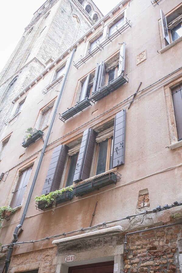 A historic building with multiple windows, some with shutters, and a visible address number '1849'. - Venetian Historic Residence at Rialto Market Square (Venezia)