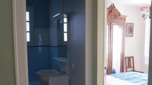 A room with a bed, a sink, and a mirror. - Spacious 3 bedroom villa near downtown, market and beaches (RONCE LES BAINS LA TREMBLADE)