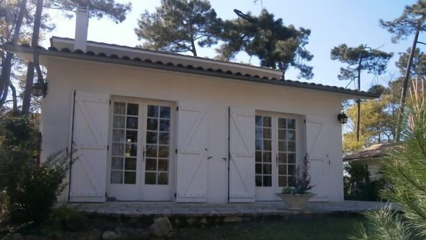 A white building with a stone foundation and a tiled roof. - Spacious 3 bedroom villa near downtown, market and beaches (RONCE LES BAINS LA TREMBLADE)