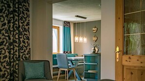 Una stanza accogliente con una porta in legno, un'area pranzo con tavolo e sedie, e un divano blu.