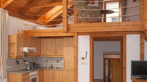 A wooden interior with a kitchen, dining area, and a loft bedroom. - Organic home, garden & swimming pond, quiet location, Vienna reached in 15 min (Maria Enzersdorf)