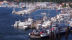 A marina with multiple boats docked at wooden piers.