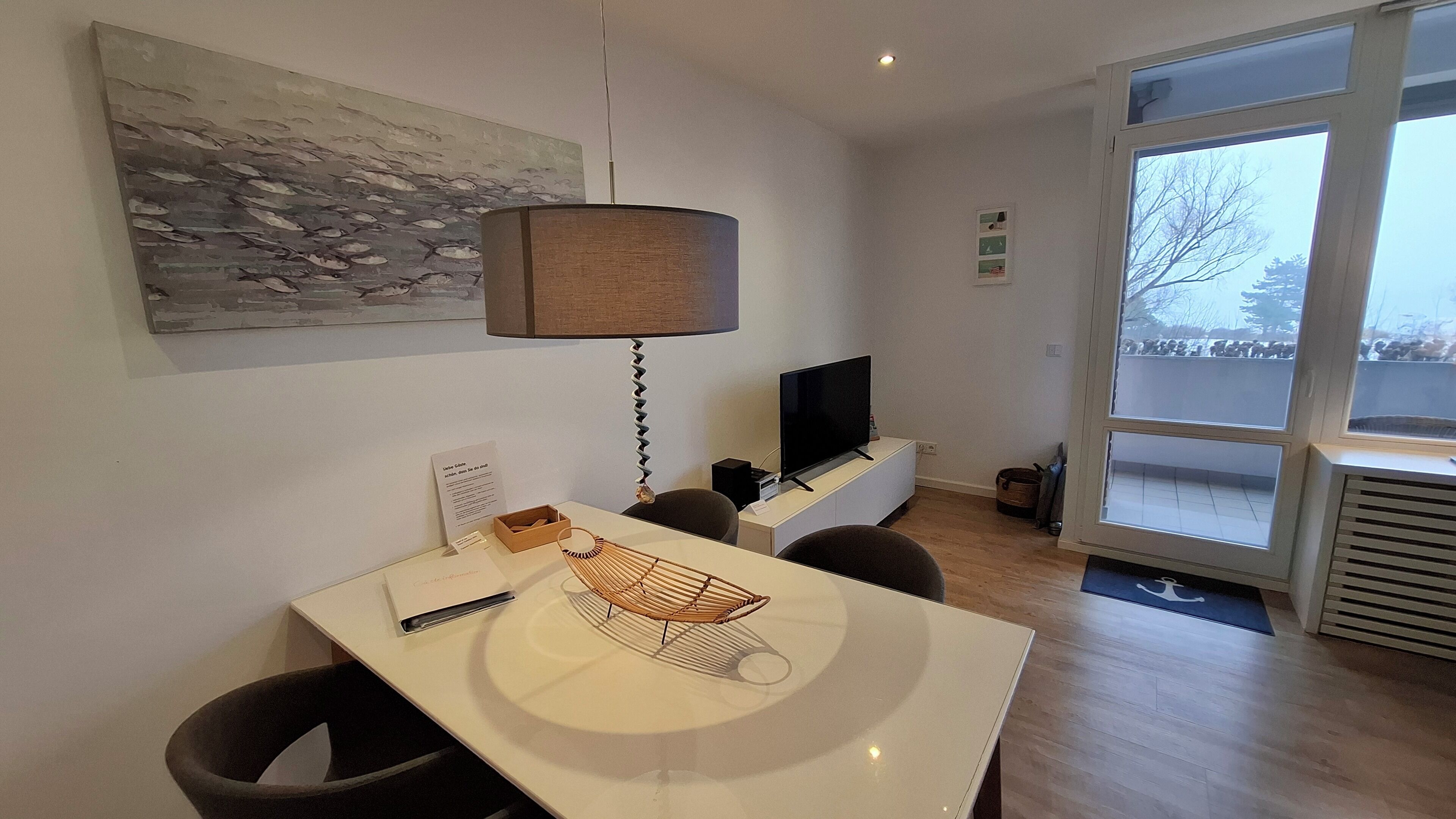 Ein modernes Wohnzimmer mit Essbereich, großem Fenster und Flachbildfernseher.