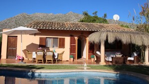 A villa with a swimming pool, outdoor furniture, and a thatched-roof structure. - WIFI Villa with garden and private pool, near the town and beaches. Pollença (Pollença)