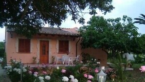 A house with a tiled roof, a wooden door, and a small porch with two chairs. - WIFI Villa with garden and private pool, near the town and beaches. Pollença (Pollença)