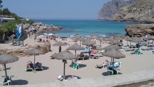 A beach with umbrellas and sun loungers, rocky cliffs, and the sea. - WIFI Villa with garden and private pool, near the town and beaches. Pollença (Pollença)