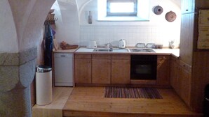 A compact kitchen with a dishwasher, a sink, and a window above the countertop. - Historic farmhouse in rural village in northern Bavaria Landscape (Wunsiedel)