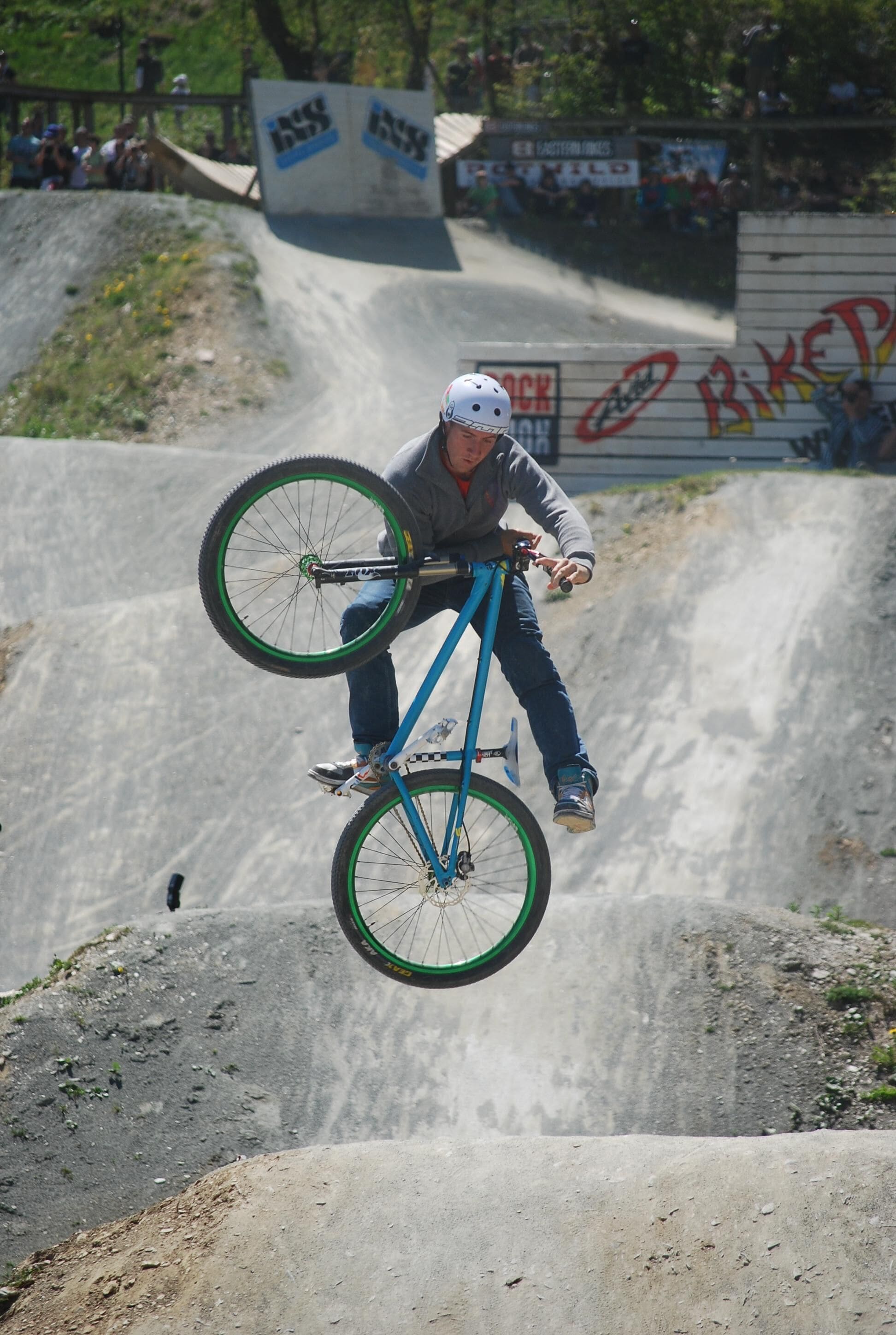 A person performing a BMX stunt on a dirt ramp.