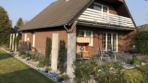 A two-story house with a sloped roof, brick exterior, and a balcony. - Modern, large 4 star house w/sauna and fireplace - 800m to the North Sea shore (Dornumersiel)