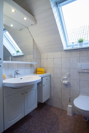 Een douche, een haardroger, zeep, toiletpapier