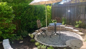 A patio with a round table, a bench, and an umbrella. - Idyllic apartment, central near the lake (Überlingen)