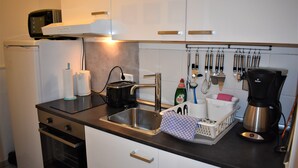 A modern kitchen with stainless steel appliances, a coffee maker, and a dish rack. - Great price in the old town and center, nice view, central, cozy with heart (Heidelberg)