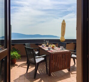 Enjoy al fresco dining with a view of the water and distant mountains from this outdoor space.