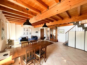 Stylish room with a large dining table, comfortable sofa, and wooden cabinet.