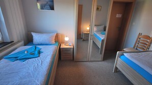A hotel room with two beds, a nightstand, a mirror, and a small table. - Vacation home Lilli 35610 - Holiday home Lilli (Uplengen)